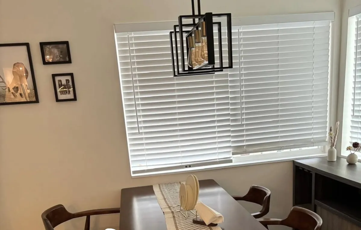 Dining room with wood table and clean window blinds